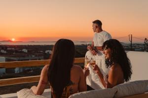 a group of people sitting on a terrace with wine glasses at Naxos Aristocratic Villa in Galanado