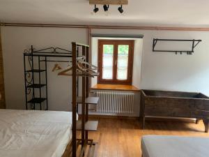 a bedroom with a bed and a tub and a window at Lu Biulè Ca' d'Aldo in Groscavallo