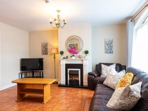 a living room with a couch and a fireplace at Kerry Holiday Homes at the Killarney Holiday Village in Killarney
