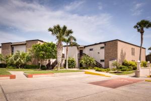 a building with palm trees in front of it at Sunchase Beachfront #210 in South Padre Island