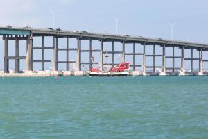 a boat in the water in front of a bridge at Sunchase Beachfront #210 in South Padre Island +27 photos