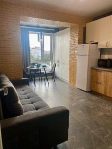 a living room with a couch and a kitchen with a table at Апартаменти Люкс, КОНДИЦІОНЕР, парковка, Авторинок, медцентр ЯНА - 5хв in Luts'k