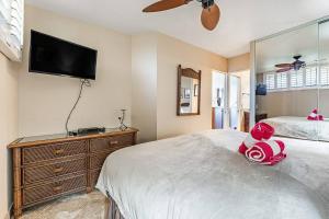 a bedroom with a bed and a tv on the wall at KS507 Spectacular Oceanfront with Split AC Wailea in Wailea
