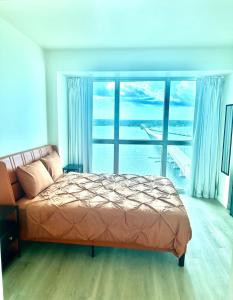 Un dormitorio con una cama y una ventana grande. en Luxe Penthouse Waterfront Loft, en Fort Myers