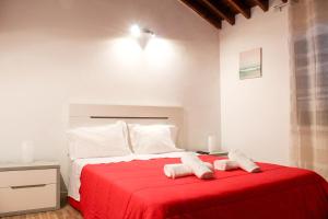 a bedroom with a red bed with two towels on it at House 37North in Mosteiros