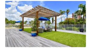 Una terraza de madera con pérgola en un patio. en Luxe Penthouse Waterfront Loft, en Fort Myers
