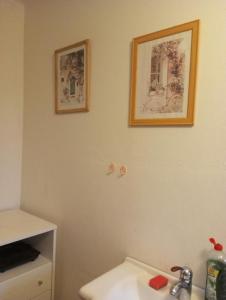 a bathroom with a sink and two pictures on the wall at Patro u Madly in Chotěšov +9 photos