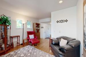 a living room with a leather couch and a red chair at Bayview Reach in Tillamook