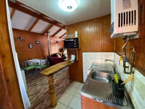 a small kitchen with a sink and a table at Cabañas San Sebastián in Valdivia +4 photos