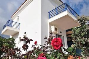 a white building with a red rose in front of it at Long Beach Koutsounari in Ierápetra +9 photos