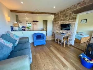 a living room with a blue couch and a stone wall at Top Barn Wales in Monmouth