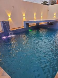a swimming pool with a waterfall in a house at TOUR EIFFEL HoTEL BENIN in Porto-Novo