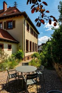 eine Terrasse mit Tisch und Stühlen vor einem Gebäude in der Unterkunft Große Pause Altes Schulhaus Schweigen in Schweigen-Rechtenbach