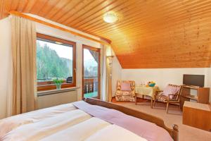 een slaapkamer met een bed en een groot raam bij Decker's Bio Hotel zum Lamm in Baiersbronn