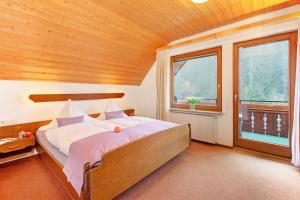 een slaapkamer met een groot bed in een houten plafond bij Decker's Bio Hotel zum Lamm in Baiersbronn