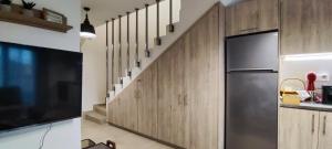 a kitchen with wooden cabinets and a refrigerator at Myrteni apartment in Nea Peramos