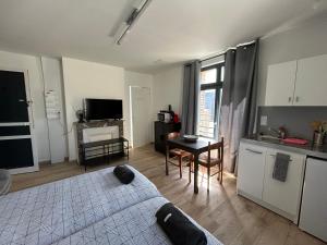 a bedroom with a bed and a kitchen with a table at Les Nids in Dieppe