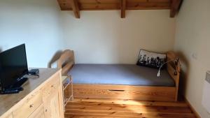 a bedroom with a bed and a desk with a television at Wycinki domek in Osiek