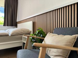 a bedroom with a bed and a chair and a plant at Ferienwohnung im Zentrum von Bad Aussee in Bad Aussee