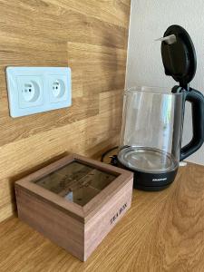 un mixeur posé sur un comptoir à côté d'une boîte dans l'établissement Treestudio Apartment, à Lipí