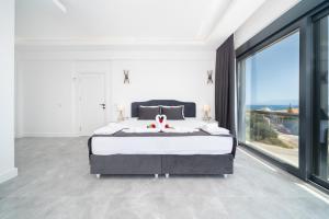 a bedroom with a large bed and a large window at Villa Bella in Kum +50 photos