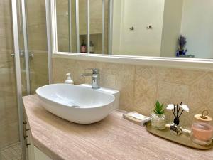 une salle de bain avec un lavabo blanc et un miroir dans l'établissement Spectacular river view apartment, à Vilnius