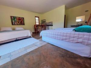 a bedroom with two beds and a table in it at Vale das Quaresmeiras in Divisa