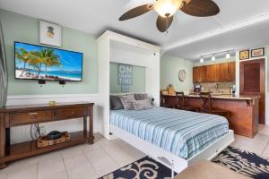 um quarto com uma cama e uma escrivaninha e uma cozinha em MV2104 Welcoming Tropical Get-Away at the Pool em Kihei