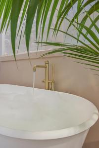 un bagno con vasca bianca e una pianta di Scarlet Apartment Vernazza Heart a Vernazza