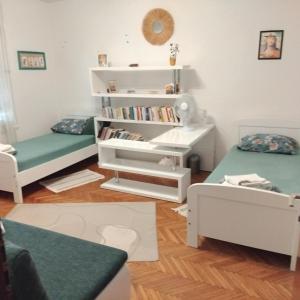a room with two beds and a book shelf at Marina Gloria in Zadvorsko
