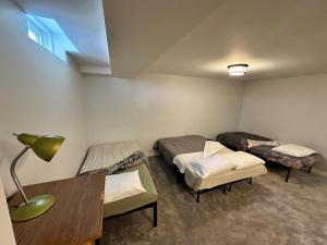 a room with two beds and a table with a lamp at Brampton Homestay in Brampton