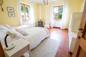 a bedroom with two beds and a table and windows at Casa del Bosco - Vista mozzafiato & Parco 4 ettari in Bobbio +18 photos