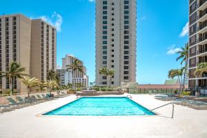 ホノルルにあるOcean View Oasis with Free Parking, A Waikiki Gem!のヤシの木や建物のあるスイミングプール