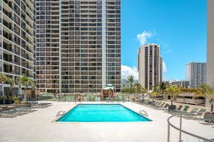 ホノルルにあるOcean View Oasis with Free Parking, A Waikiki Gem!の高層ビルの前のスイミングプール