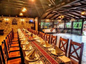 a long table in a room with tables and chairs at Curtea Domneasca in Cricova