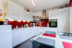 a kitchen with white cabinets and a red wall at Daheim am Wasserturm - Wörth in Wörth am Rhein