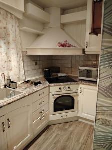 a kitchen with white cabinets and a stove top oven at Afrodite Apartment in Chrysoupolis