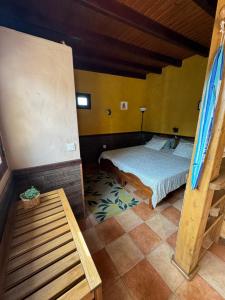 a bedroom with a bed and a bench in a room at CASA TAMARA APalmera BDátil in Haría