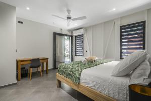 a bedroom with a bed and a desk with a chair at Villa Kimloa in Case-Pilote +21 photos