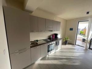 a kitchen with white cabinets and a sink at Lagoon Apartment mit Pool Boa Vista in Sal Rei