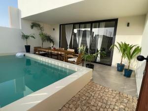 a house with a swimming pool and a dining room at Lagoon Apartment mit Pool Boa Vista in Sal Rei