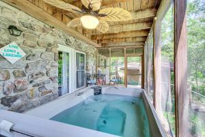 a bath tub in a room with a large window at Hot Springs Retreat with Private Dock and Hot Tub! in Hot Springs