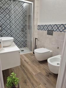 a bathroom with a toilet and a sink and a shower at Domu MariaLuisa in Selargius