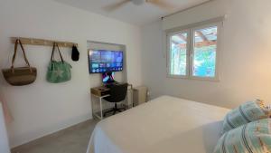 テウラーダにあるCasa Palmerita a 7 minutos andando de una playa de aguas cristalinasのベッドと机とテレビのある寝室