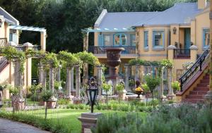 une maison avec un jardin en face dans l'établissement Franschhoek Country House & Villas, à Franschhoek
