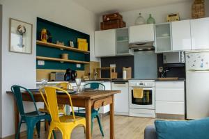 a kitchen with a wooden table and yellow chairs at Le Sardinier in Camaret-sur-Mer