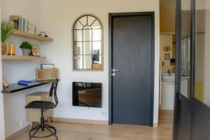 a black door in a room with a desk and a mirror at Le Sardinier in Camaret-sur-Mer