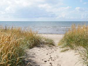 a beach with footprints in the sand and the ocean at 4 person holiday home in FALKENBERG in Falkenberg +7 photos