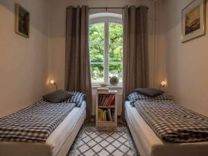 two beds in a room with a window at Holiday apartment Kutscherstube in Altenbeken
