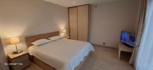 a bedroom with a bed and a flat screen tv at Šventojoje Parko 10 in Palanga
